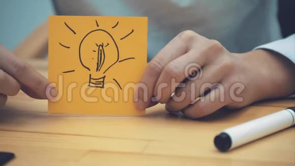 商业营销计划和人的概念用一个标记在黄色上画一盏灯来特写女人的手视频的预览图