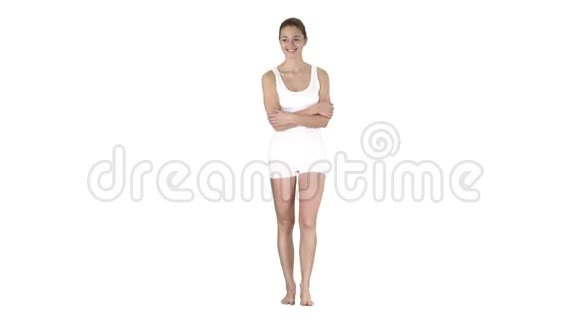 年轻女子穿着白色运动服赤脚行走在白色背景上微笑视频的预览图