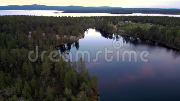 傍晚鸟瞰美丽的北方风景无人机飞越湖面和森林视频的预览图