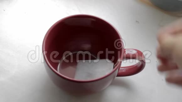 泡在红珊瑚杯的茶包里用水壶里的开水泡茶视频的预览图