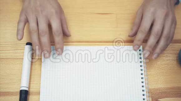年轻的女人手放在桌子上女人的手一张白色的纸上用黑色的记号笔描绘着微笑的概念视频的预览图