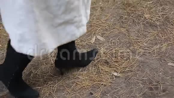 女人脚穿着秋靴穿着黑色连裤袜在公园小径上视频的预览图