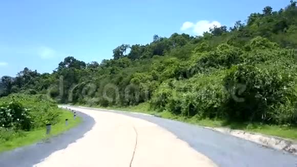 夏天绿树旁的灰色白色蜿蜒的道路视频的预览图