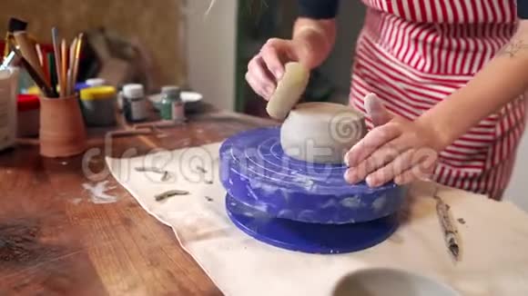 女雕塑家正在陶艺工作室制作黏土杯特写镜头视频的预览图