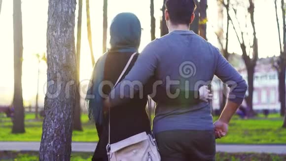 戴头巾的男人和女人在公园拥抱视频的预览图