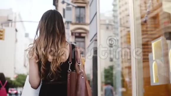 镜头跟随年轻成功的女商人走在纽约市的街道后购物慢动作视频的预览图