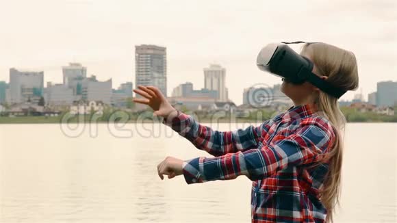一个年轻女孩戴着VR耳机背景是大城市高清视频的预览图