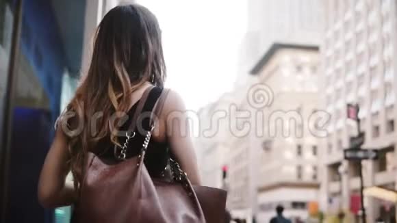 自信的高加索女商人戴着太阳镜留着美丽的头发沿着纽约市慢动作走着视频的预览图