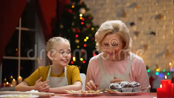 美丽的老太太和女孩玩得开心准备圣诞饼干快乐的假期视频的预览图