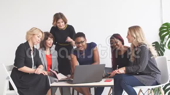 积极的妇女一边坐在桌旁一边讨论组织计划视频的预览图