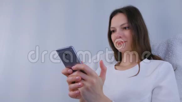 女人在手机上看有趣的视频视频的预览图
