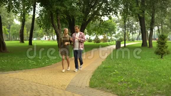 成年爸爸和可爱的女儿在公园散步分享他的生活经历视频的预览图