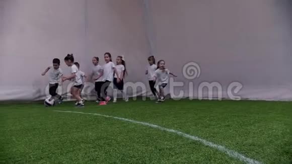 室内足球场小孩子在踢足球一个小男孩带球视频的预览图