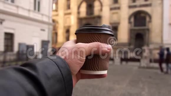 他手里拿着咖啡沿着街走人们都在咖啡在奔跑视频的预览图