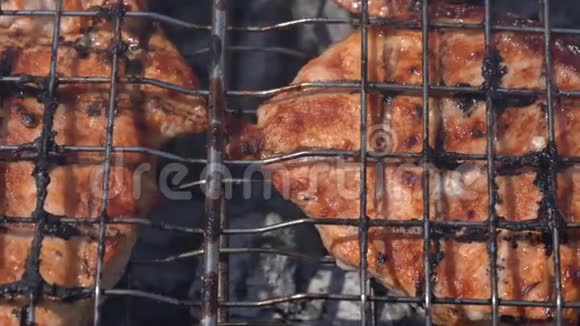 美味多汁的猪肉牛排在木炭烤架上的金属串上烹饪带有芳香的火烟夏季野餐烹饪视频的预览图