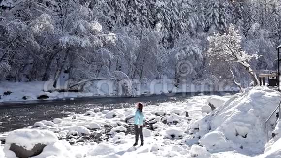 一个年轻的女孩走在森林附近冬季景观视频的预览图