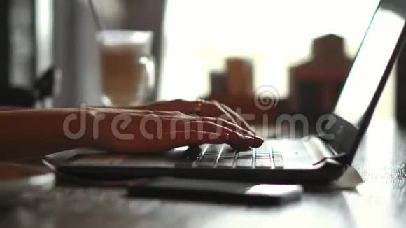 在坐着的时候用手提电脑上的触摸滚动垫将穿着一件亮黄色上衣的随便穿着的女商人的详细拉近视频的预览图