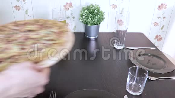 女人在家里摆桌子准备家庭晚餐或午餐然后在上面放上新鲜的意大利披萨视频的预览图
