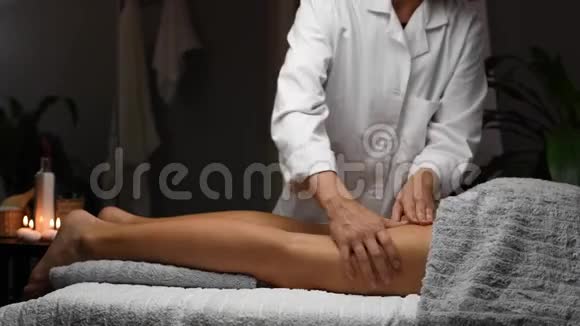 在水疗中心接受抗纤维素按摩的女性按摩师做专业的腿部按摩视频的预览图