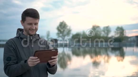 人在看数字垫成年男子正在使用平板电脑在森林里旅游视频的预览图