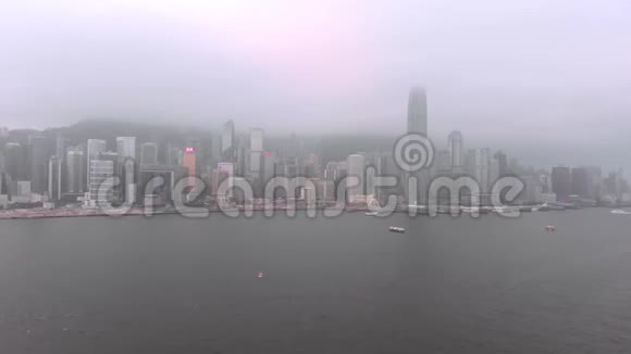 雾蒙蒙的香港全景在维多利亚湾上空飞行的无人机视频的预览图
