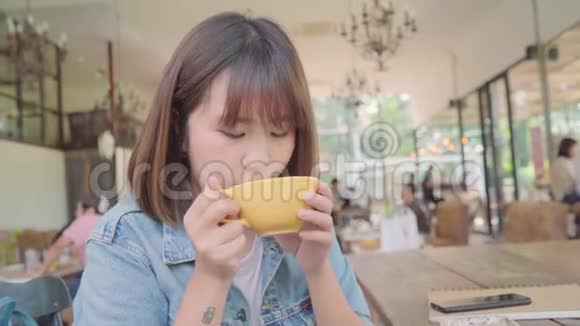 商业自由职业的亚洲女性在咖啡馆里坐在桌上喝着温茶或咖啡视频的预览图