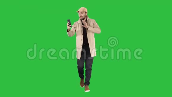 秋季时尚风格男子录制视频博客行走在绿色屏幕Chroma键视频的预览图