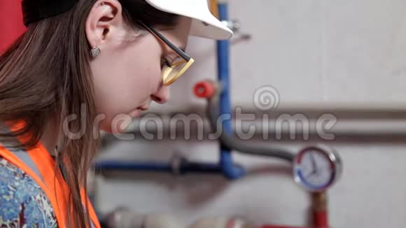 女工程师检查锅炉房供暖系统设备的数据视频的预览图