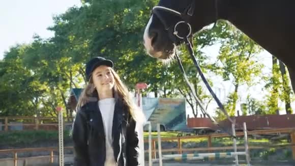 可爱的戴帽子的年轻女孩来了看着黑马的头摆姿势视频的预览图