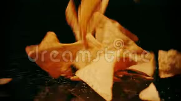破碎的玉米饼碎片落在黑色背景下慢镜头视频的预览图