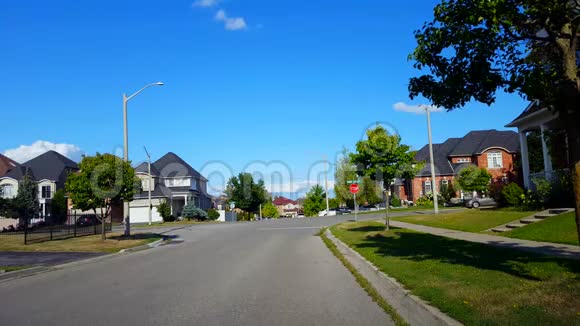 郊区城市街道与车辆交通的观点日间市区道路及住宅旁视频的预览图