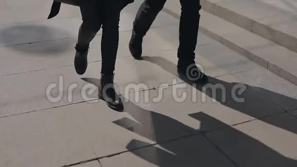 一对不可辨认的夫妇的腿沿着城市小巷走视频的预览图
