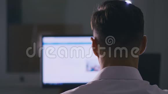 后视图男子浏览电脑显示器上的互联网网站网页浏览搜寻资料的概念视频的预览图