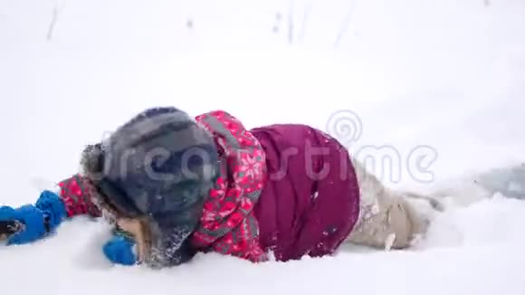 孩子躺在雪地里冬天的游戏视频的预览图
