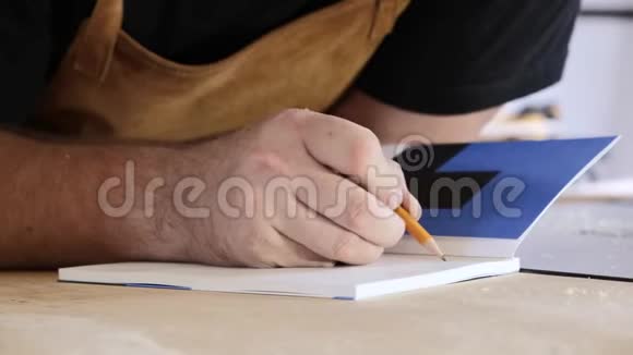一个人在日记里写条目伙计专业人士在笔记本上做笔记木匠在他的房子里做计算视频的预览图