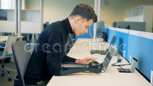 残疾人坐在一张有笔记本电脑的桌子旁视频的预览图