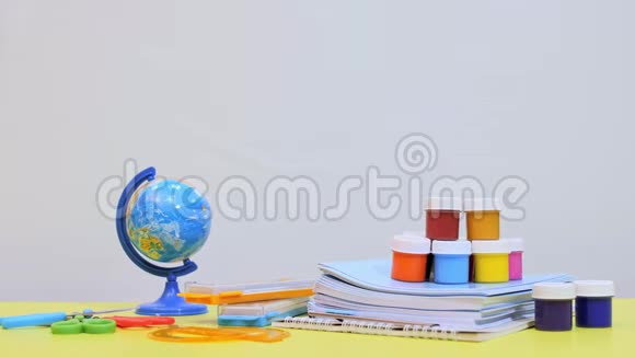 桌子上有写字的材料一个孩子手绕着地球视频的预览图