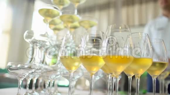带酒杯的桌子和香槟酒用于婚礼服务员把香槟倒进玻璃杯里香槟酒滑梯视频的预览图