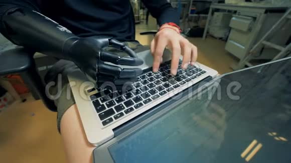 一个机器人手在膝上电脑上的工人4K视频的预览图