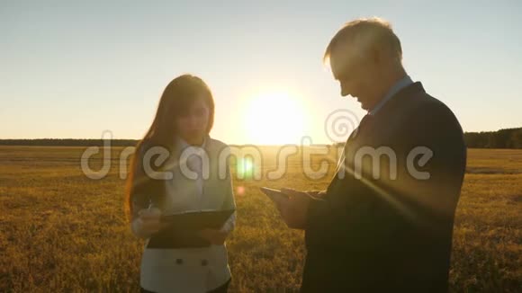 商务男士带着公文包商务女士带着平板电脑正在夕阳下谈笑风生商务会议视频的预览图