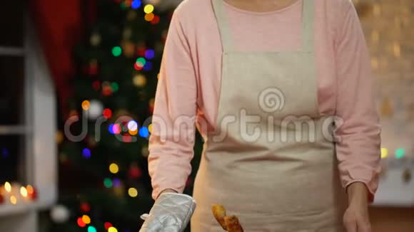 女士从餐桌上端来烤鸡和家人一起准备圣诞节视频的预览图