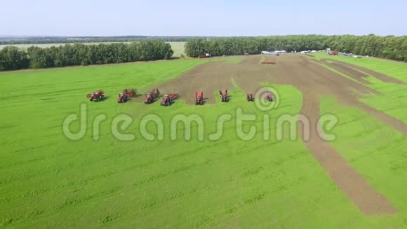 农业机械的空中表演在农村的绿色田野上一起骑马视频的预览图