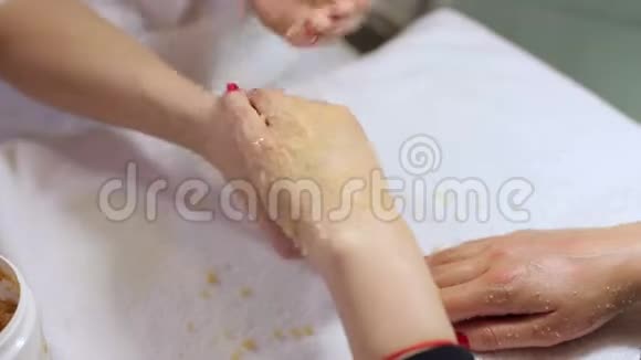 在美容院一位美容师正在给女人的手擦洗视频的预览图