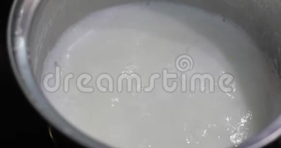 用煮沸的牛奶在锅里加入薄片高能量早晨食品视频的预览图