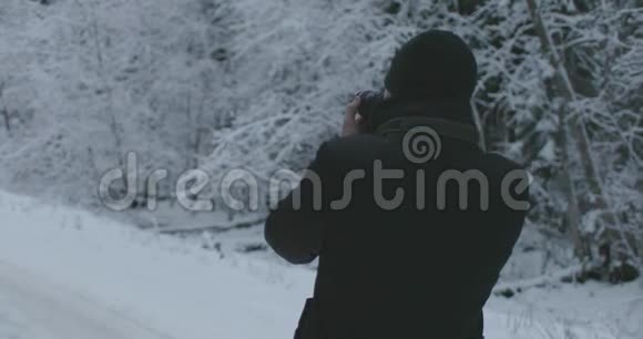 带着相机的人在冬天的森林里拍照视频的预览图