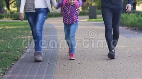 快乐的女孩放学后和父母散步吹嘘有趣的课程视频的预览图