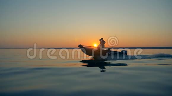 太阳升起两个人在渔船上航行视频的预览图