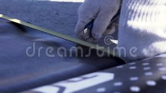 为工人用白色防护手套用技术切割器切割一张黑色的Ruberoid剪辑视频的预览图
