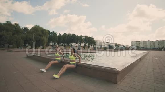 穿运动服的两名年轻女性做三头肌运动有滑滑梯的效果视频的预览图