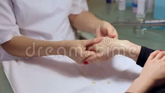 在美容院一位美容师正在给女人的手擦洗视频的预览图